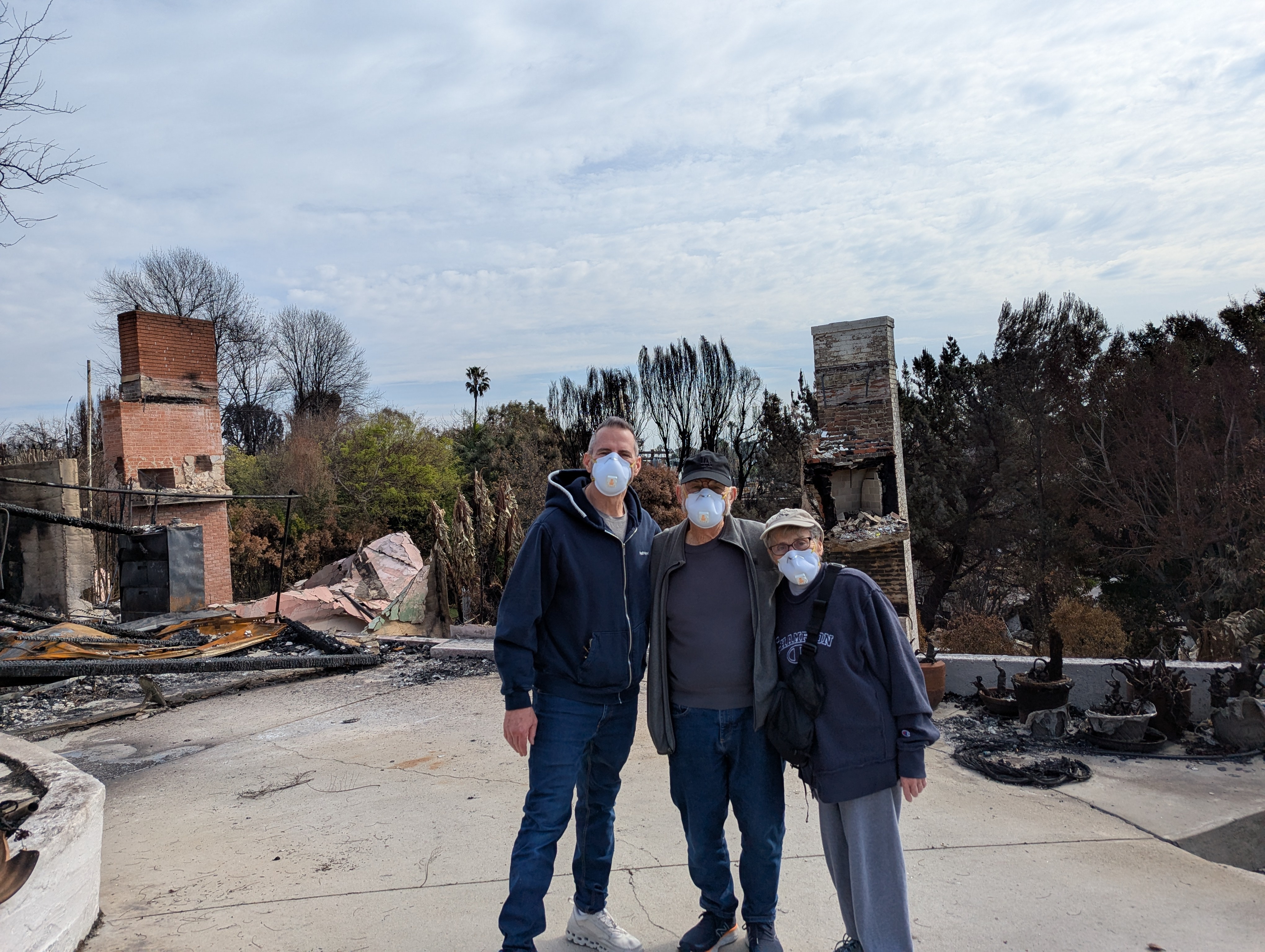 Co-founder's family standing in front of their home lost in the 2025 LA fires